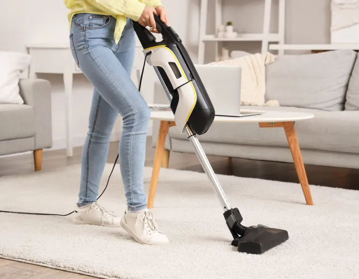 A woman vacuuming a rug